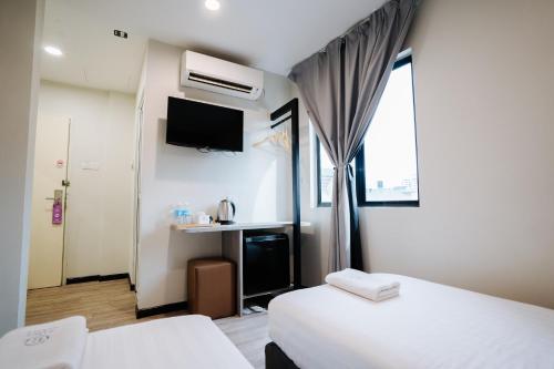 a hotel room with two beds and a tv at Wangs Hotel Gurney Drive in George Town