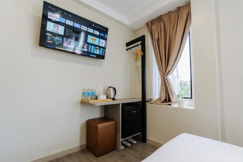 a room with a tv on the wall at Wangs Hotel Gurney Drive in George Town