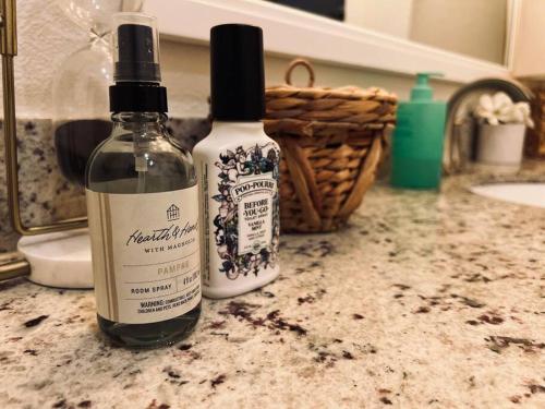 two bottles of alcohol sitting on a bathroom counter at Harper's House Modern Home in West Fayetteville in Fayetteville