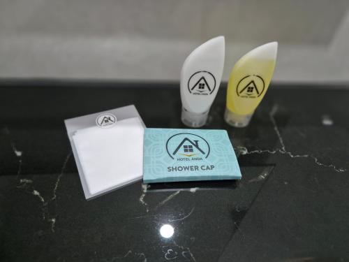 une table avec deux cuillères et une boîte de crème solaire dans l'établissement Hotel Anda, à Jember