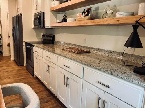 a kitchen with white cabinets and a counter top at Harper's House Modern Home in West Fayetteville in Fayetteville