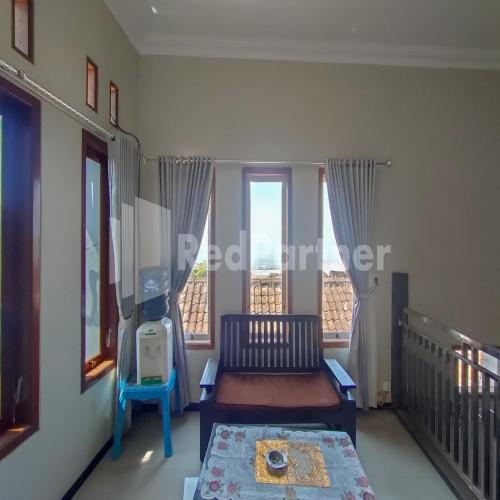 a living room with a couch and a large window at Villa Dua Dua RedPartner in Tlekung