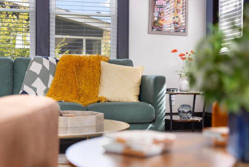 a living room with a green couch and a table at Walk to State Street - Remodeled Home in Bristol