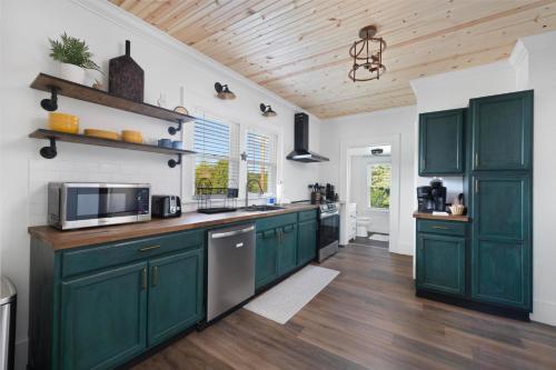 a kitchen with green cabinets and a wooden ceiling at Walk to State Street - Remodeled Home in Bristol