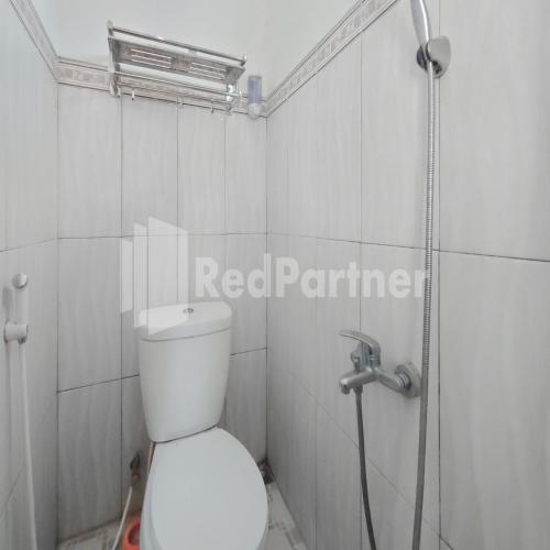 a bathroom with a white toilet and a shower at Villa Dua Dua RedPartner in Tlekung