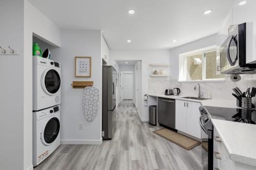 a white kitchen with a washer and dryer at Serenity 1BR & 1 DEN Home at Folsom Ave in Coquitlam