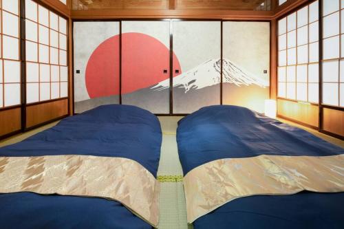 a bedroom with two beds in a room with windows at Vacation Home 和BISABI in Matsumoto