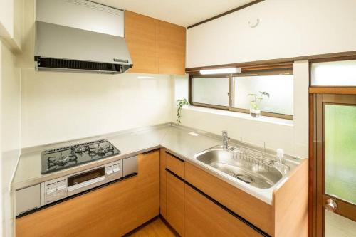 a small kitchen with a sink and a stove at Vacation Home 和BISABI in Matsumoto