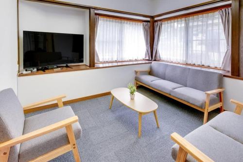 a living room with a couch and a tv at Vacation Home 和BISABI in Matsumoto