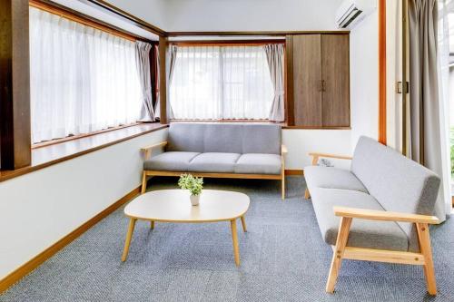 a living room with a couch and a table at Vacation Home 和BISABI in Matsumoto