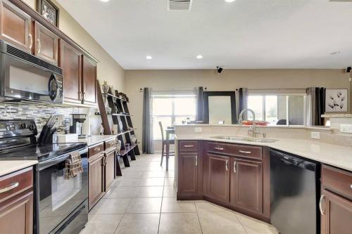 a large kitchen with wooden cabinets and appliances at Golf Course Community! Amazing Home for 8 Guests in Valrico