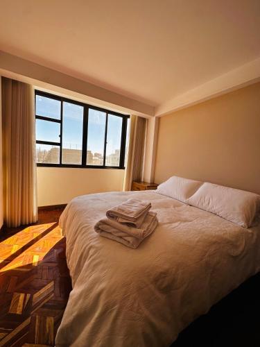 a bedroom with a bed with towels on it at NJ Apartment in Uyuni