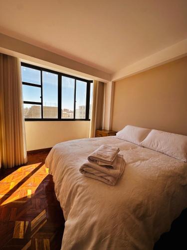 a bedroom with a bed with towels on it at NJ Apartment in Uyuni