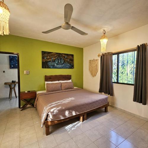 a bedroom with a bed and a ceiling fan at Casa Alux Azul in Valladolid