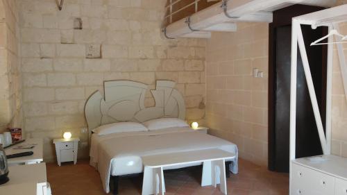 a bedroom with a white bed with two lights on it at Le Dimore Dell' Idris in Matera