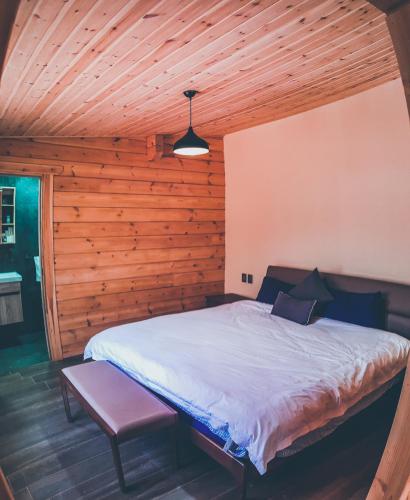 a bedroom with a bed in a wooden cabin at Cabañas Santa Barbara in Mazamitla