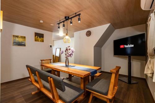a dining room with a table and chairs and a tv at 清水屋大阪西九条駅前 in Osaka