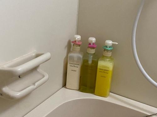 tre bottiglie di prodotti per la pulizia accanto a un lavandino di Azabujuban Properties 401 - the sanctuary a Tokyo