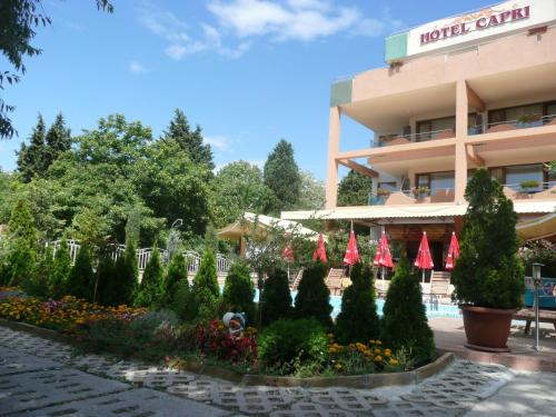 a hotel with a garden in front of a building at Hotel Capri in Nesebar