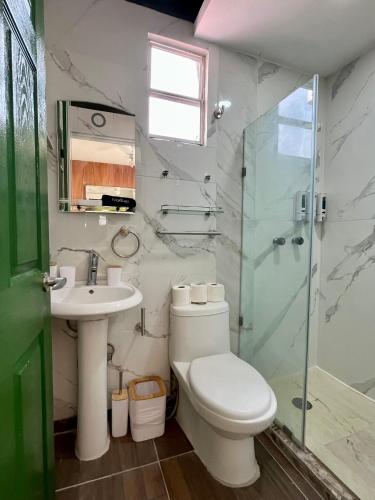 a bathroom with a toilet and a sink and a shower at La Puerta Blanca Penthouse #8 in Puerto Vallarta