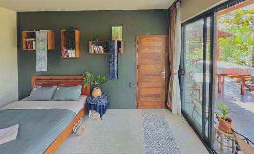 a bedroom with a bed and a sliding glass door at Comfy Riverside Mekong homestay Ben Tre in Ấp Phú Hòa (3)