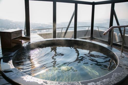 a hot tub on top of a building with a view at Tennomaru in Gamagori