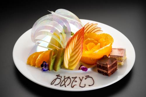 a plate of food with fruit and a happy birthday at Tennomaru in Gamagori