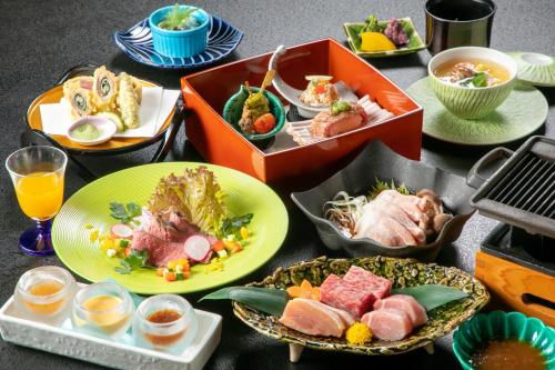 a table topped with plates of food and bowls of food at Tennomaru in Gamagori