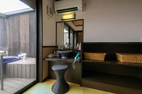 a bathroom with a sink and a mirror and a stool at Tennomaru in Gamagori