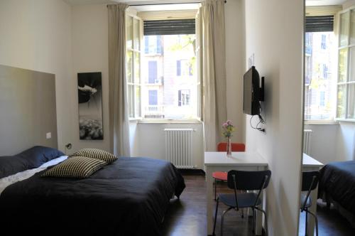 una camera con letto e scrivania e due finestre di Guest House Interno4 a Roma