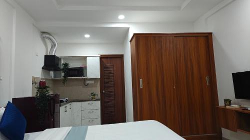 a bedroom with a bed and a wooden cabinet at 116 Home Tales by Tipiverse, BTM Layout - NO CAR PARKING in Bengaluru