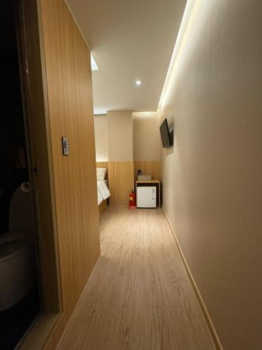 a hallway with a room with a bed and a room with a hallway at Well Plus Guest House in Seoul