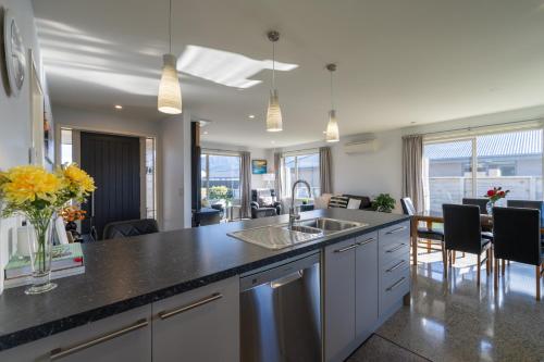 a kitchen with a counter and a dining room at Cozy Haven - Te Anau Holiday Home in Te Anau