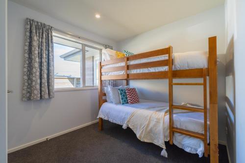 a bedroom with a bunk bed and a window at Cozy Haven - Te Anau Holiday Home in Te Anau