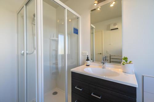 a bathroom with a sink and a shower at Cozy Haven - Te Anau Holiday Home in Te Anau