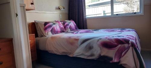 a small bedroom with a bed with a window at Bed and Breakfast Happy Home Taupo Accommodation in Taupo