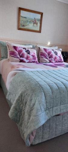 a bedroom with a large bed with pink and gray sheets at Bed and Breakfast Happy Home Taupo Accommodation in Taupo