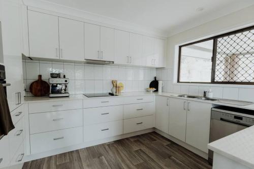 a white kitchen with white cabinets and a window at Acreage property, pet friendly, outdoor campfire in Bald Knob