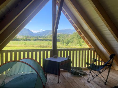 a tent and a table and a chair on a porch at Camping Baleia in Pui