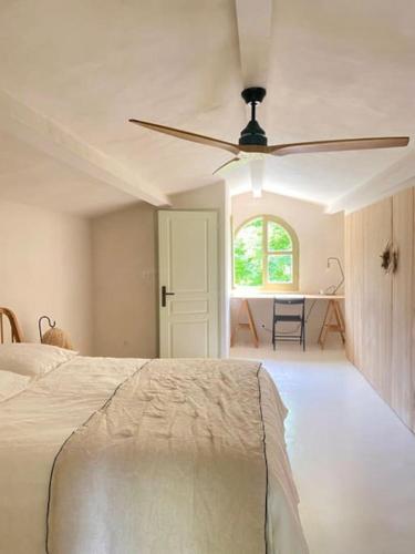 une chambre avec un lit et un ventilateur de plafond dans l'établissement Batubela, à Mougins