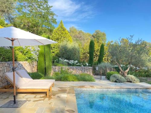 un parasol et une chaise à côté de la piscine dans l'établissement Batubela, à Mougins