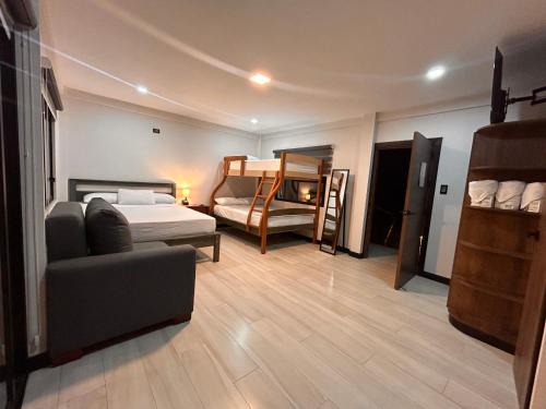 a room with a bed and a couch and a bedroom at OCEAN DRIVE LODGE in Montañita