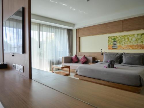 a bedroom with a large bed and a couch at The Senses Resort & Pool Villas, PHUKET in Patong Beach
