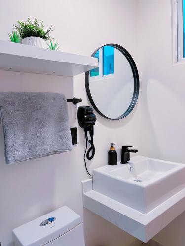 une salle de bain blanche avec un lavabo et un miroir dans l'établissement El Almendrito, à La Sabana