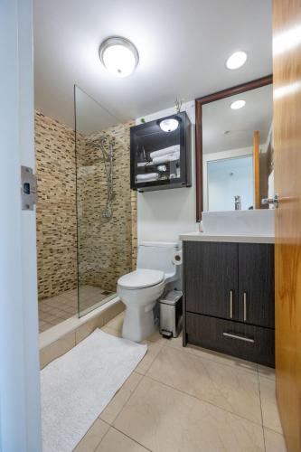 a bathroom with a toilet and a shower and a sink at Modern top-floor 1-bedroom loft with free parking in Vancouver