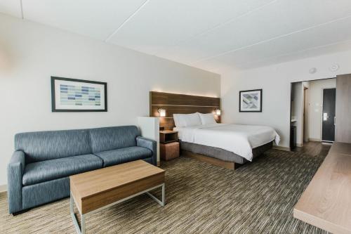 a hotel room with a bed and a couch at Holiday Inn Express & Suites - Welland in Welland