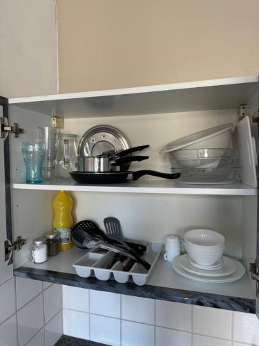 - une étagère de cuisine avec de la vaisselle et des ustensiles dans l'établissement Studio Centre Ville 6, à Valence