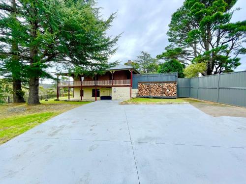 a driveway leading to a house with a fence at Linden Lodge in Linden