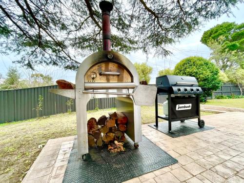 a wood fired oven with a grill and a smoker at Linden Lodge in Linden