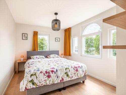 ein Schlafzimmer mit einem Bett und zwei Fenstern in der Unterkunft Villa in Koksijde near the Sea in Koksijde